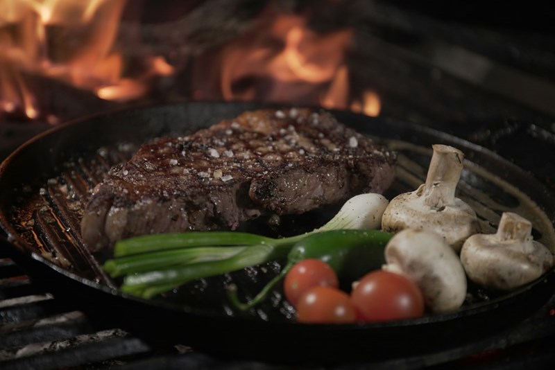 Wagyu steak and vegetables cooking on a grill