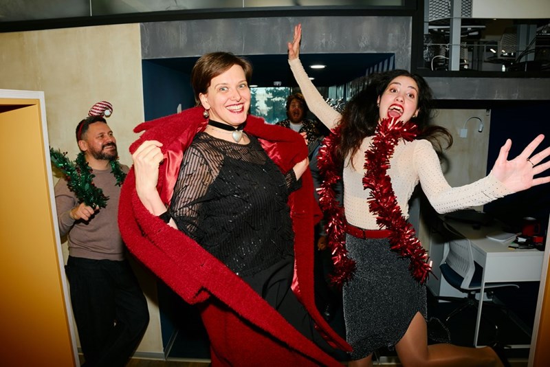 2 coworkers excitedly celebrate costume party in red attire.