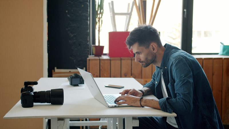 A stressed out employee looks at a laptop
