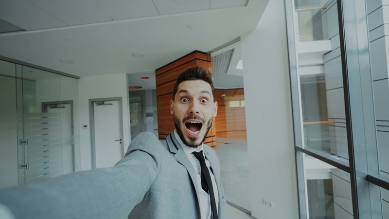 Man in suit taking a selfie with surprised expression