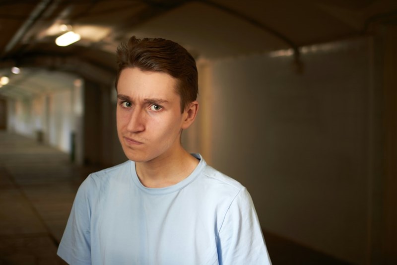 A man looks skeptical in a dark tunnel