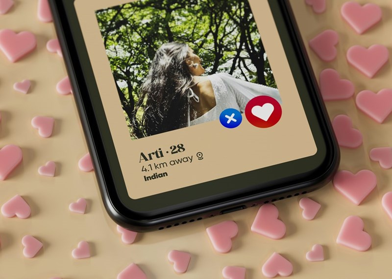 A dating app profile displayed on a phone screen, surrounded by scattered pink heart shapes.