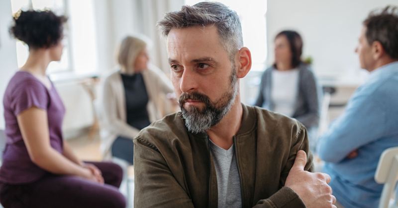 Man failing to be funny in front of a group of people. 