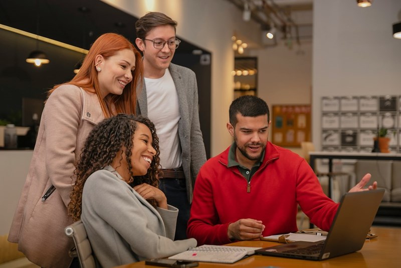 An employee shows his coworkers the “circling back” tracker he built.