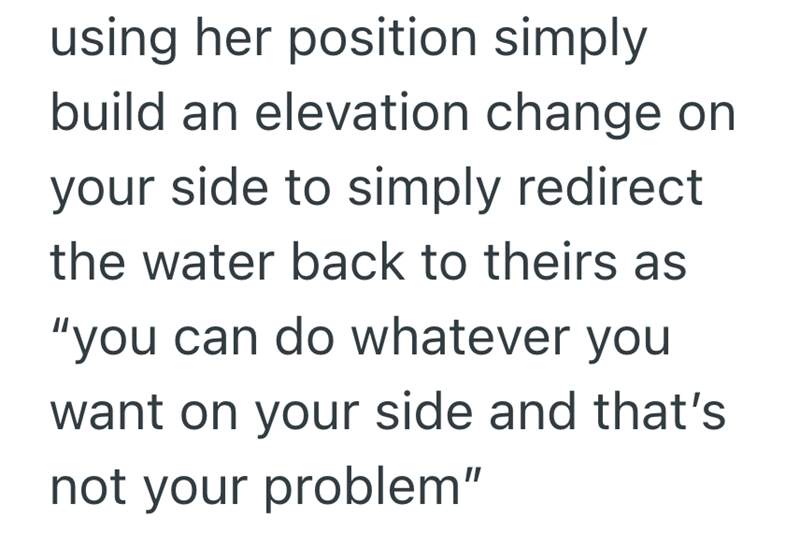 using her position simply build an elevation change on your side to simply redirect the water back to theirs as "you can do whatever you want on your side and that's not your problem"