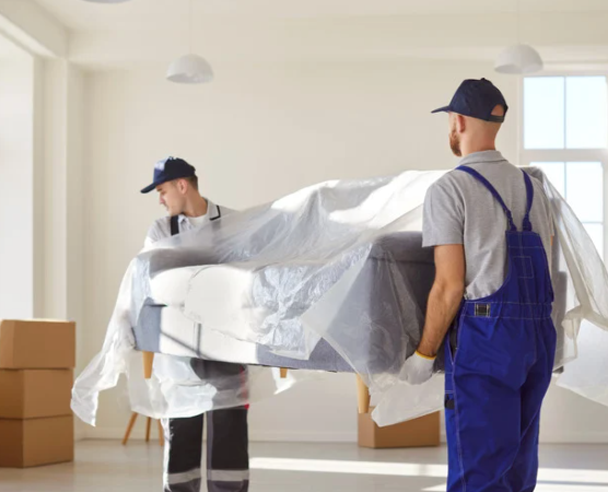 Professional movers hauling a couch out of someone's living room.