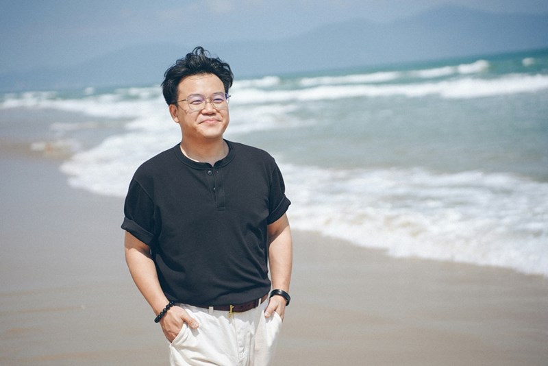 Man in black shirt walks on sandy beach