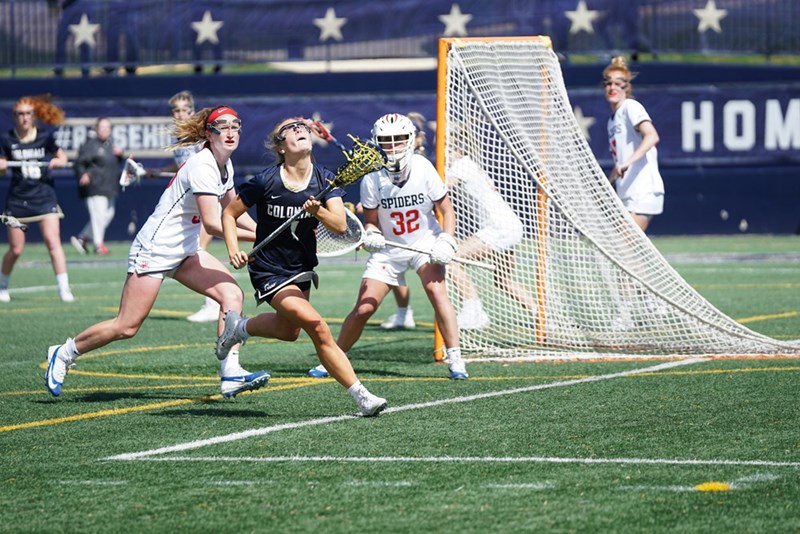 Female lacrosse players playing a game of lacrosse