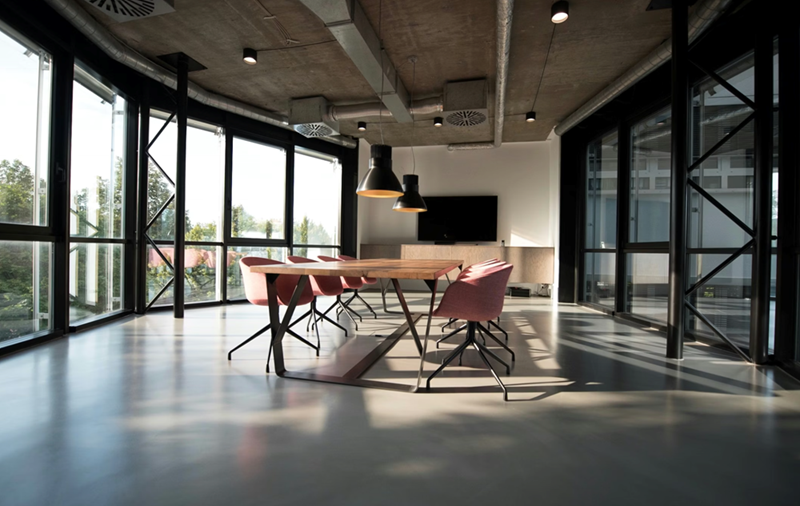 An empty conference room with natural ambient lighting and pink chairs