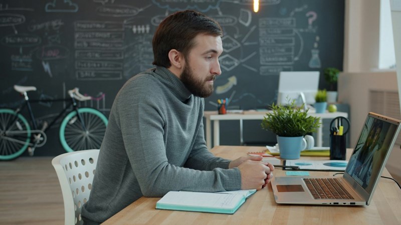 A man works on a laptop in a modern office space