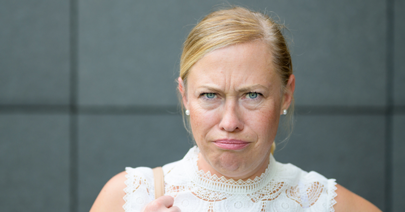 Older woman glaring and looking upset with someone.
