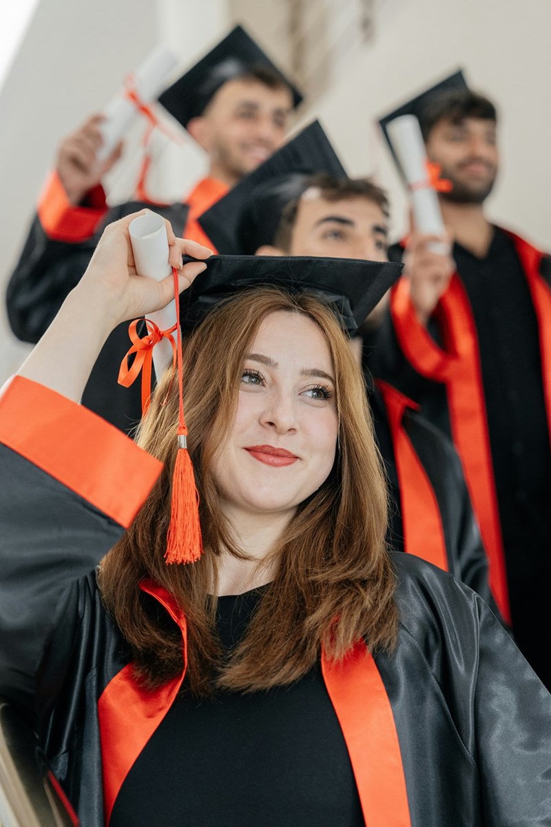 Smiling college graduates receive their diplomas.