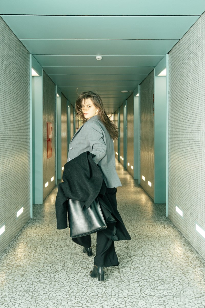 Woman walking down a hallway, looking back