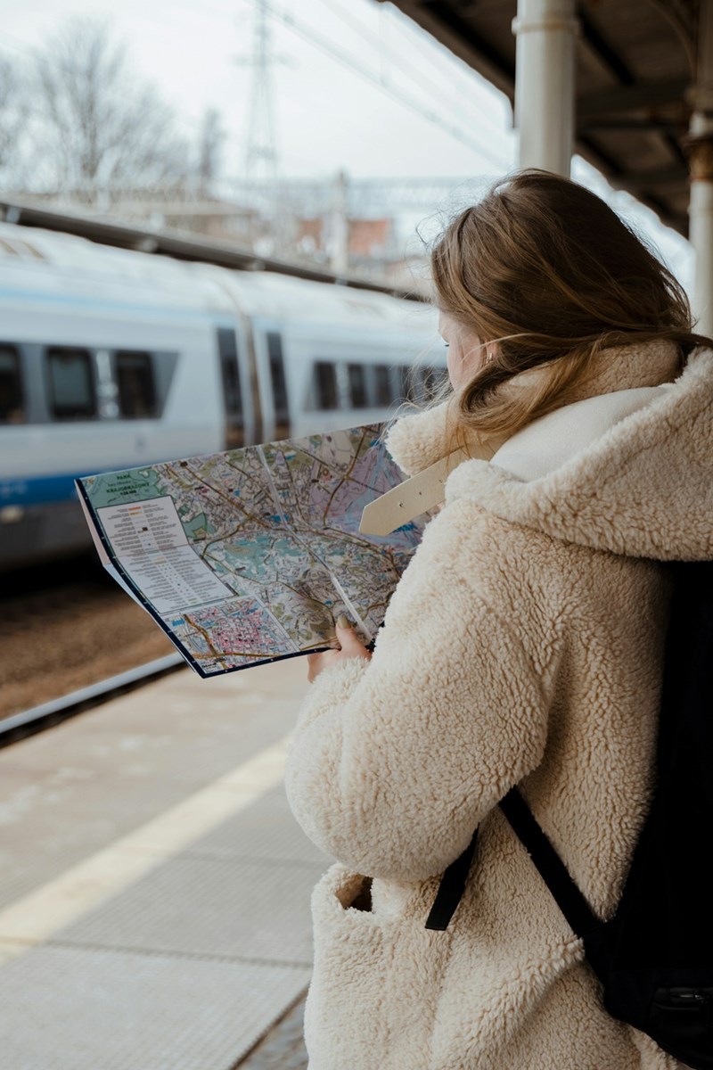 A woman looking at a map while waiting for a train