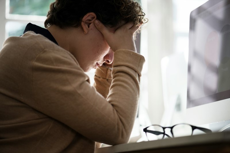 A businesswoman looks at her computer, stressed