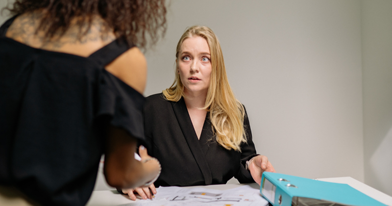 Two women discussing their personal lives at work.