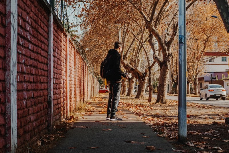 A man stands outside in his neighborhood during the daytime