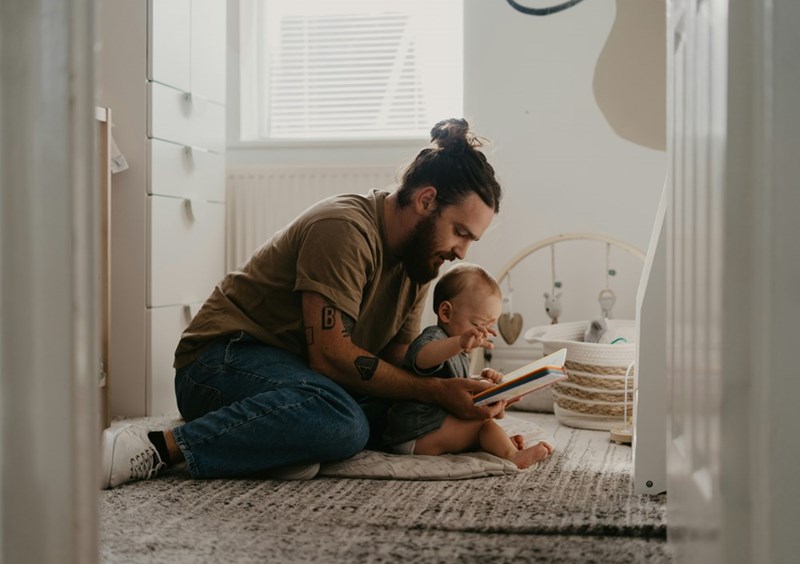 New Dad reads his baby a book.