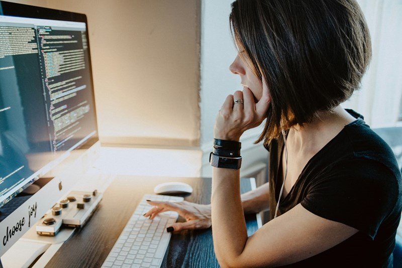 Woman wearing black t-shirt holding white computer keyboard