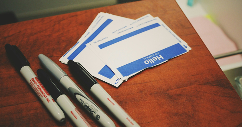 Marker pens and name stickers sitting on a table