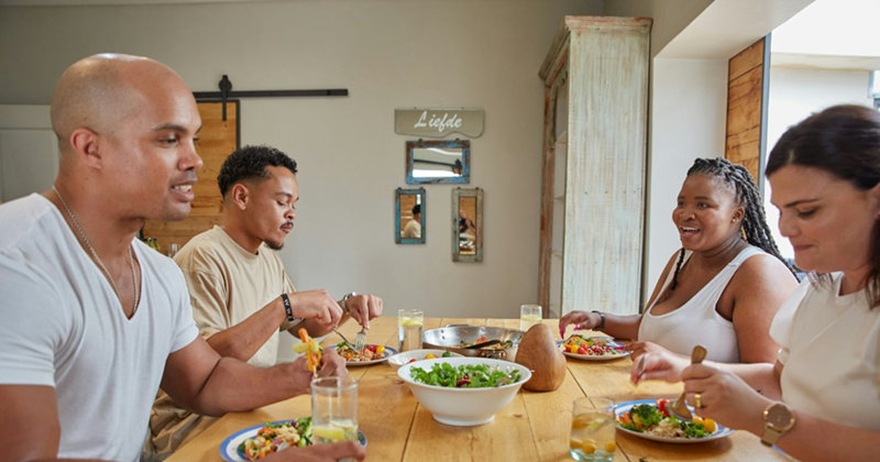 Two men and two women eating food at a dinner table