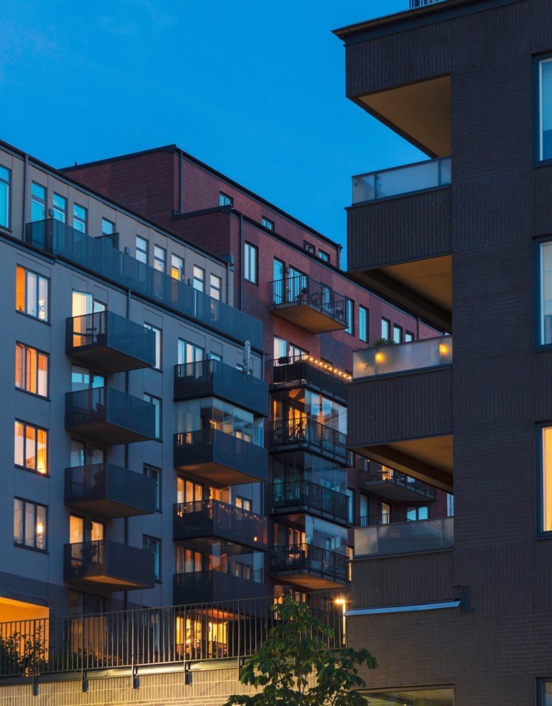 Two apartment buildings with facing windows, showing close living spaces. 
