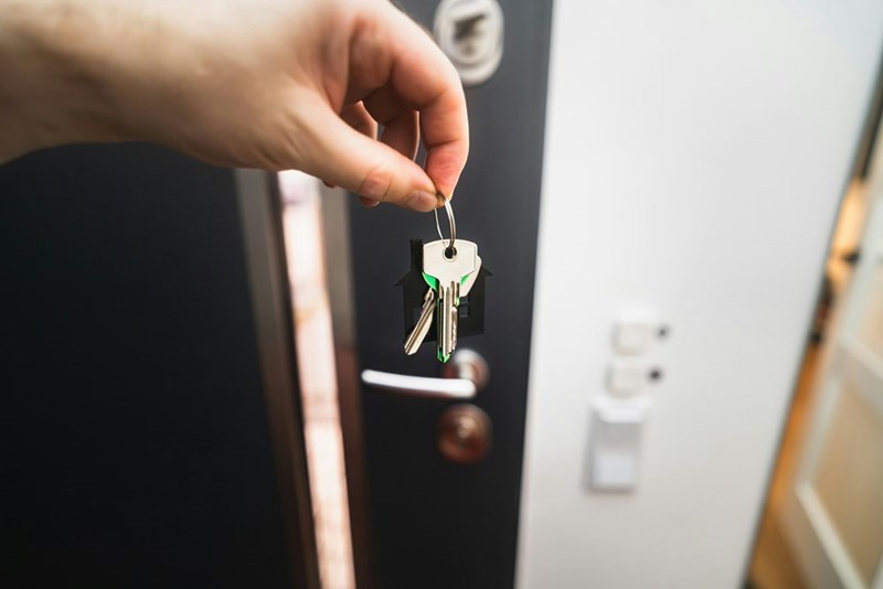 A person holds their keys to the front door of their apartment.