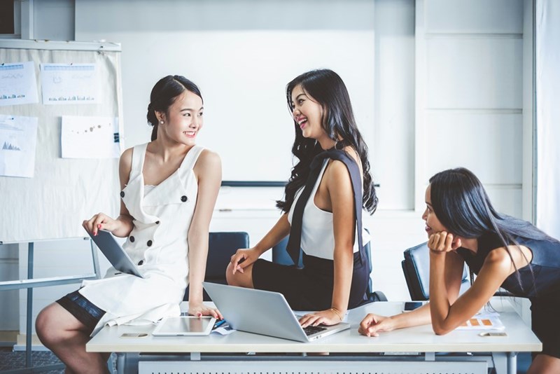 Employees laugh and gossip together.