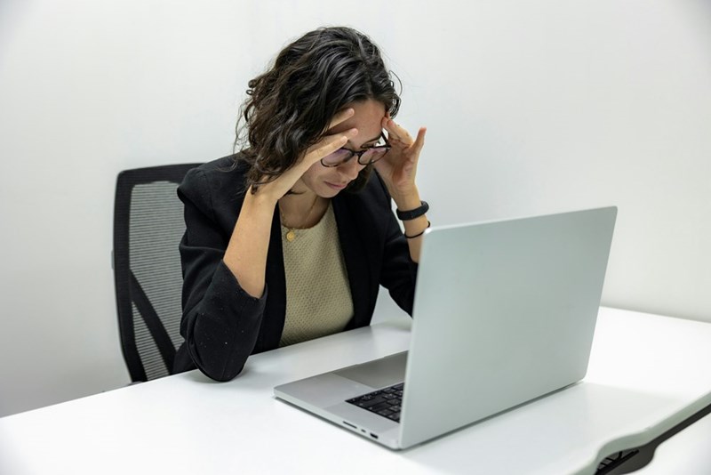 A woman at work looks confused at her laptop