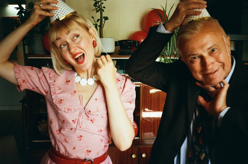 Mom celebrates her birthday with her husband next to her as both wear party hats.