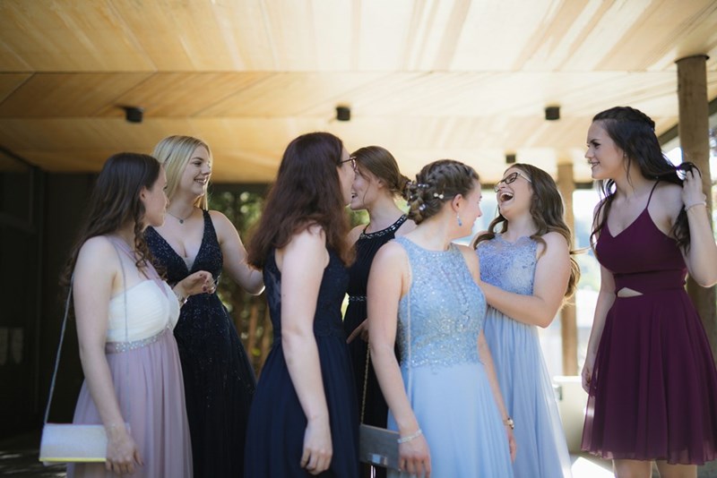 A group of high school girls talk and laugh with each other before the Prom