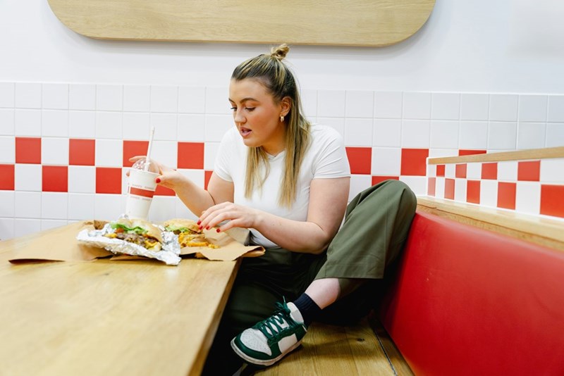 A teen worker takes a break at their fast food service job