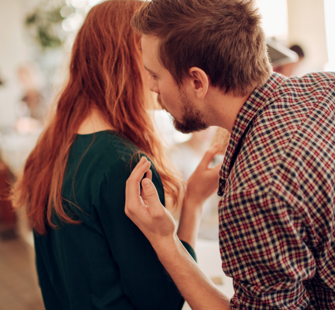 Man whispering to his coworker in the office.