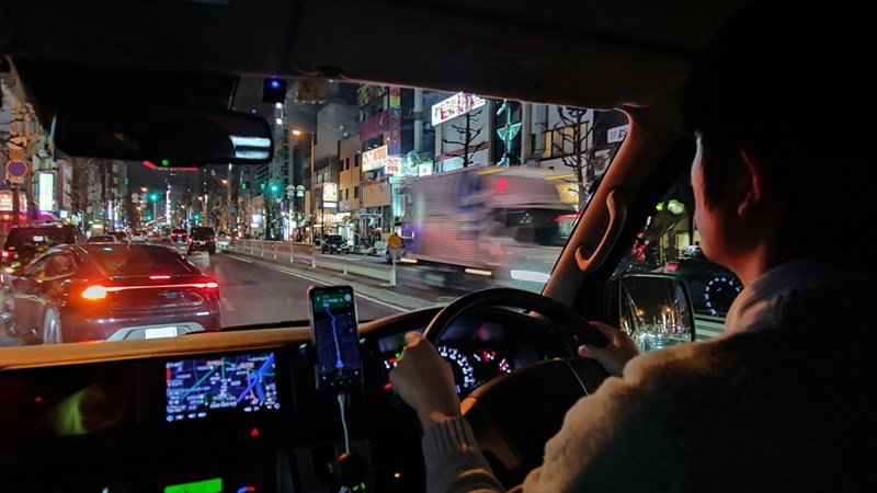 Driver in Japan steers through busy streets.