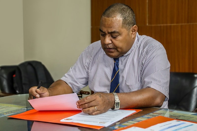 A man sitting at a table with papers in front of him