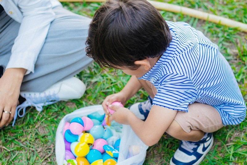 A little boy playing with a basket of Easter eggs