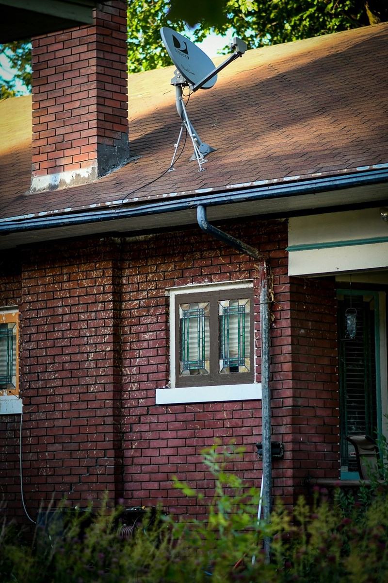Satellite dish on the side of a home in a nice suburban neighborhood