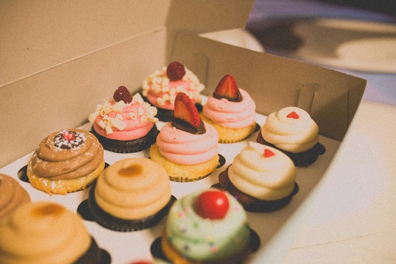 Box of mini cakes with different flavors, delivered as a thoughtful gift.