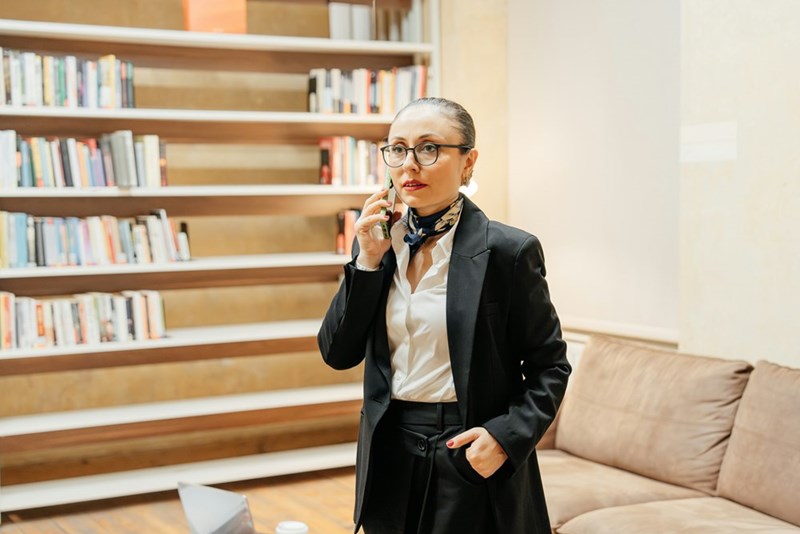 A woman in a suit talks on the phone in the office