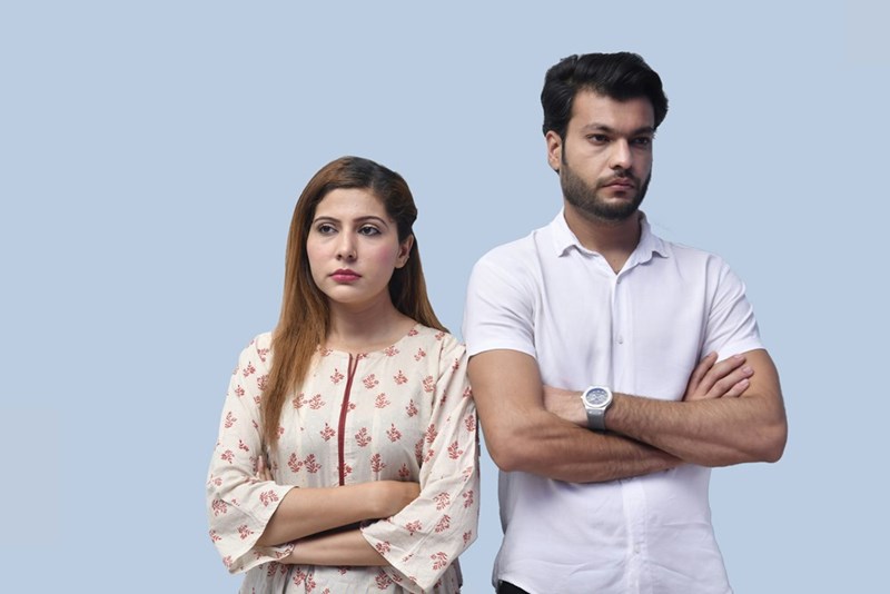 The couple stands in silence, both visibly frustrated and disconnected.