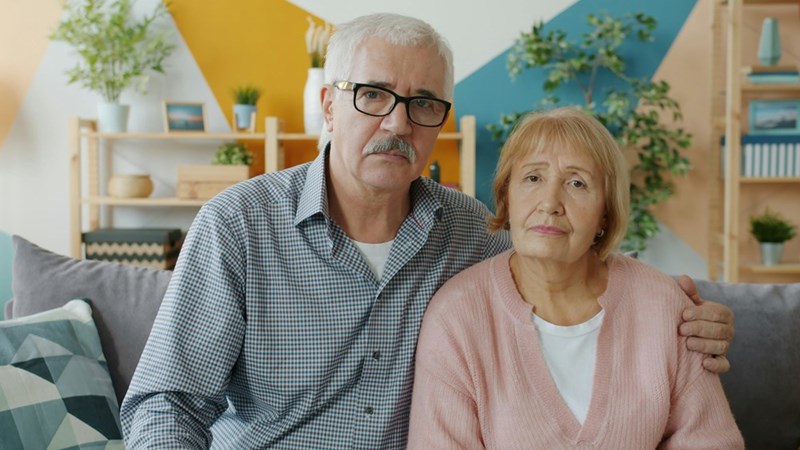 Two parents looking upset at home, illustrating family tension.