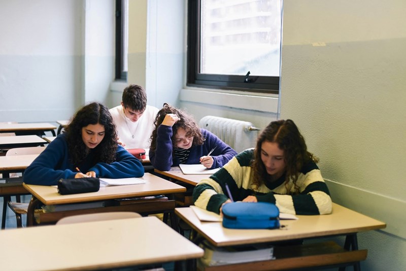 A classroom full of students takes notes without the assistance of electronic devices.