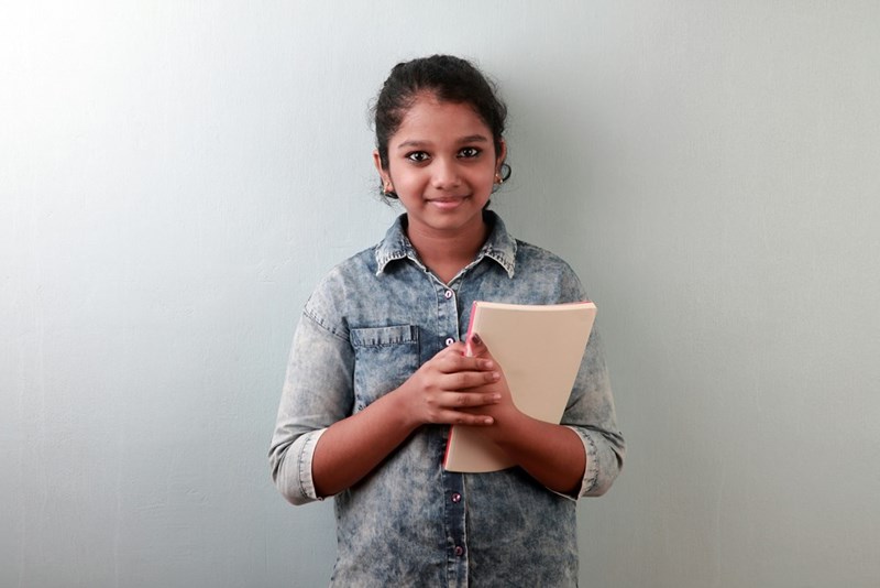 Portrait of a happy smiling girl holding a book