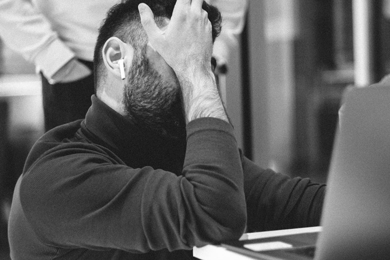 An employee facepalms at work