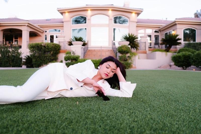 A wealthy woman lies on the front lawn of her mansion