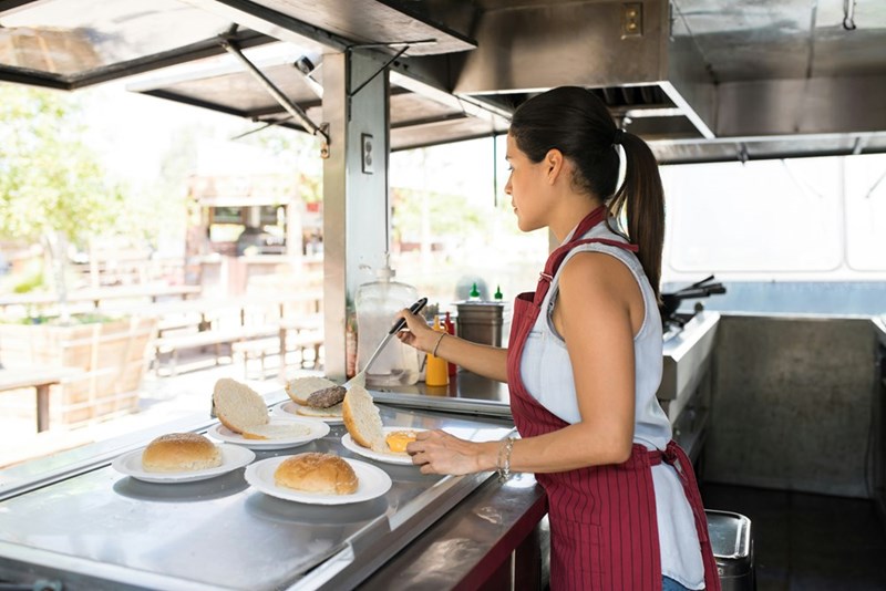 Employee assembles hamburgers for customers.