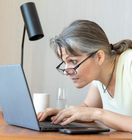 Older woman furiously typing an email to the HOA.