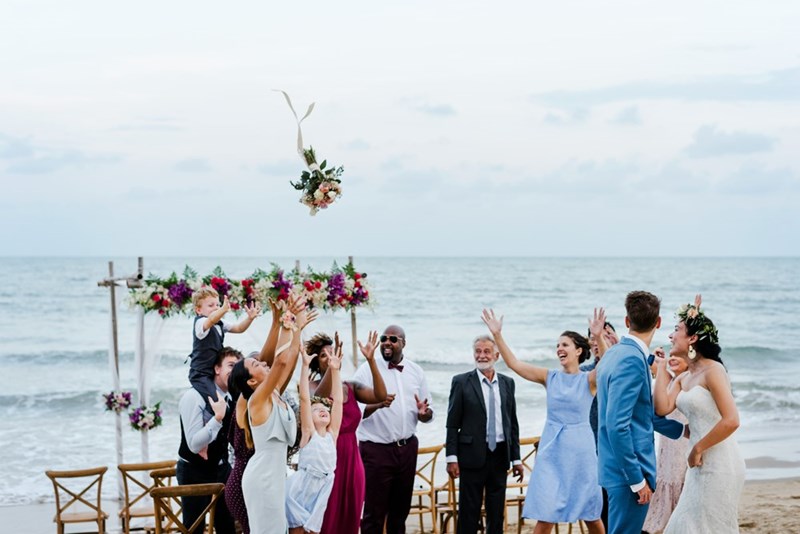 Bride tosses her bouquet to wedding guests.