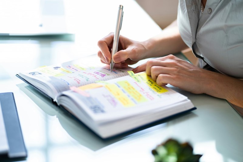 Woman writing in her notebook to schedule an appointment