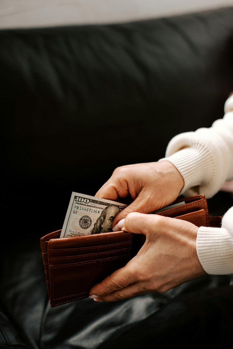 Woman counting dollars from her wallet.